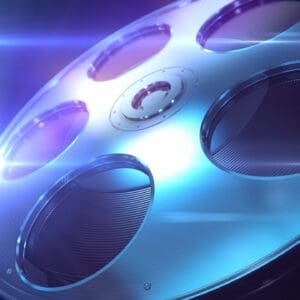 Close-up of a metallic film reel with blue lighting.